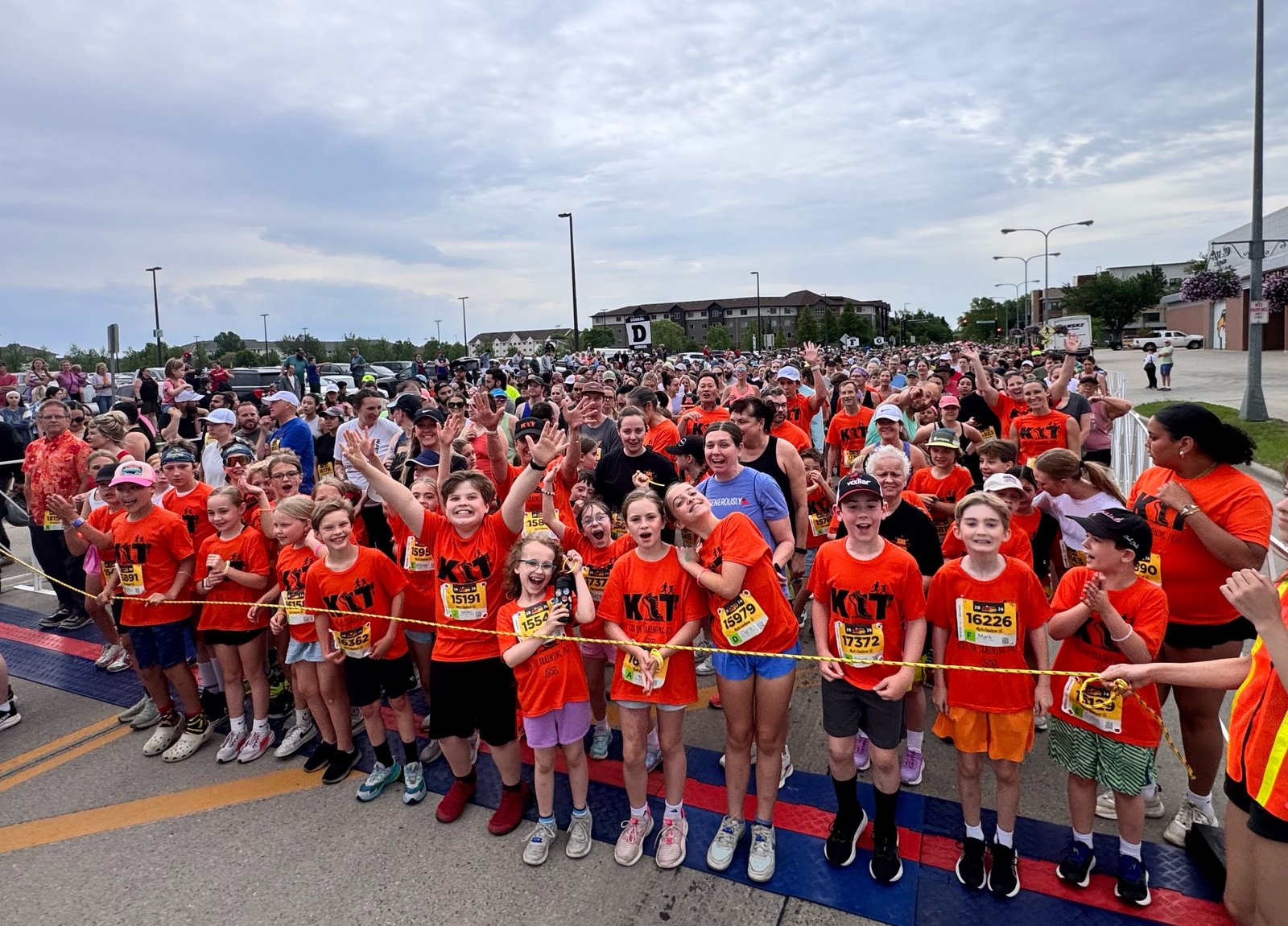 Kids in Training runners in orange KIT shirts packed behind the tape at the start of the Fargo Marathon 5K